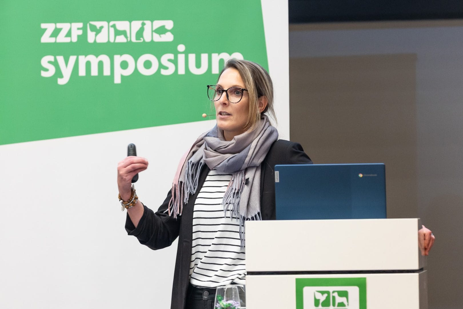 Referentin spricht am Rednerpult vor einer Wand mit dem Schriftzug ZZF Symposium